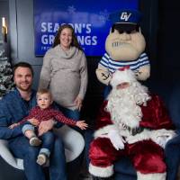 Parents with young boy smile with Santa and Louie